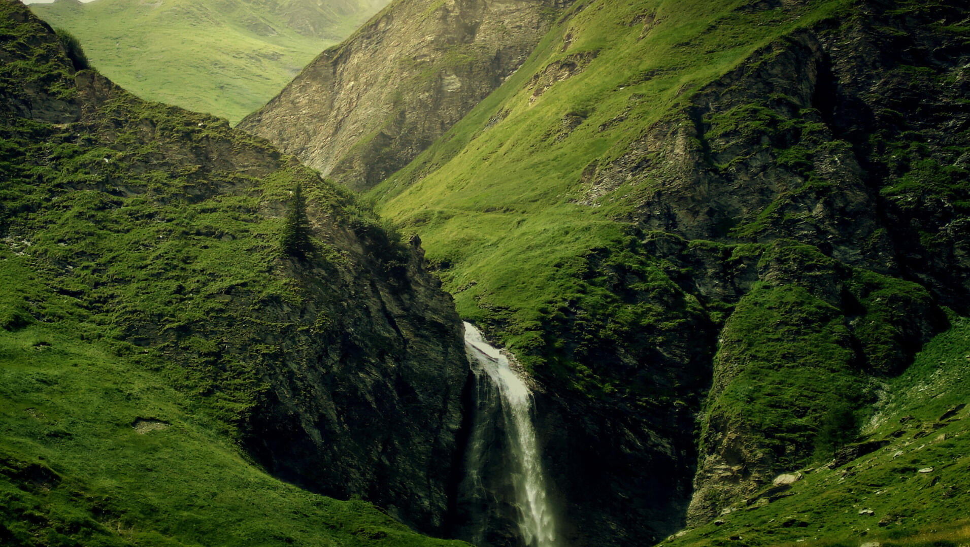 Lush green mountains and a waterfall in the Madeira forest